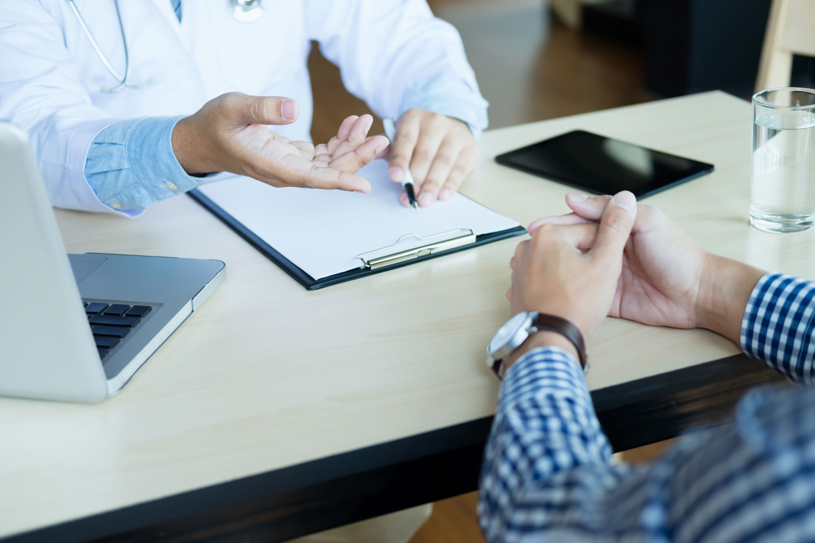 Doctor speaking with a patient over a desktop