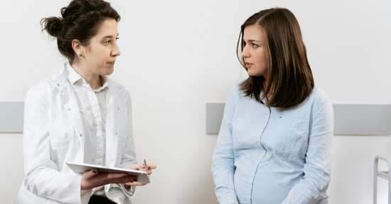 Woman speaking to her doctor about maternal health