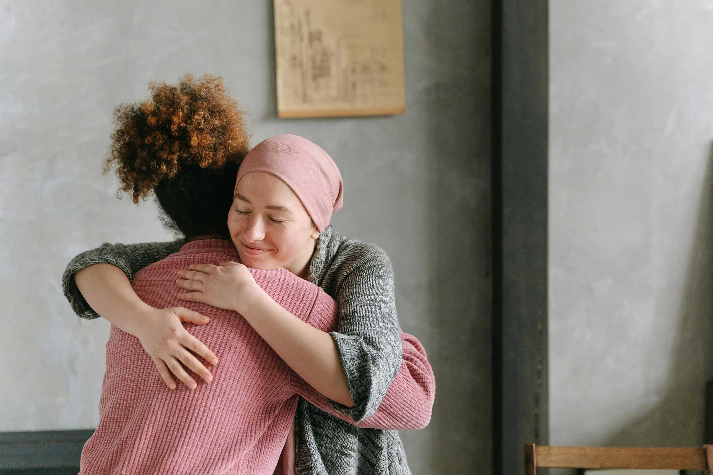 Cancer patient hugging a nurse in a hospital setting